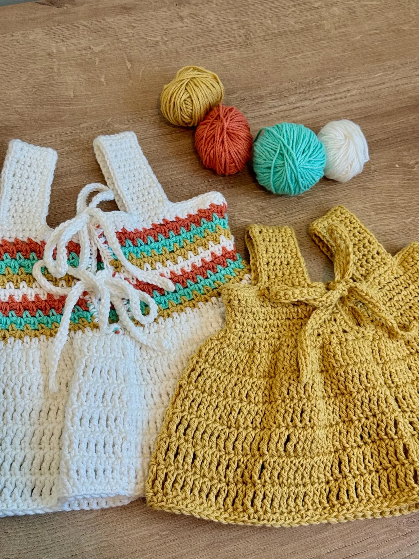 Coastal Stripes tops beside the colorful yarn used to make them